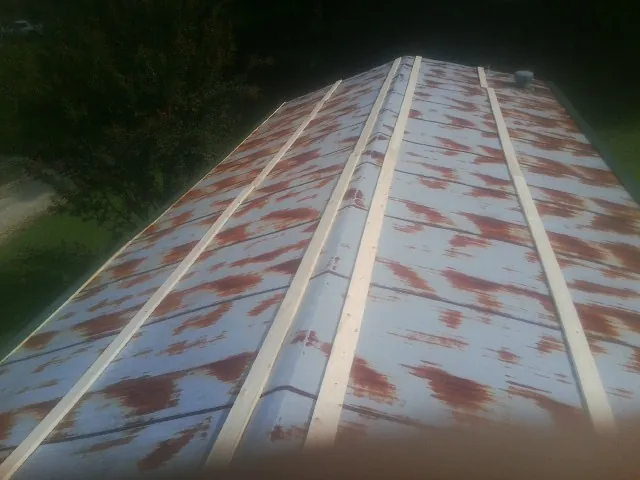 Rusted metal roof panels with new wood purlins before replacement — Storm Damage Roof Repair in New Madison by Roofing Brothers