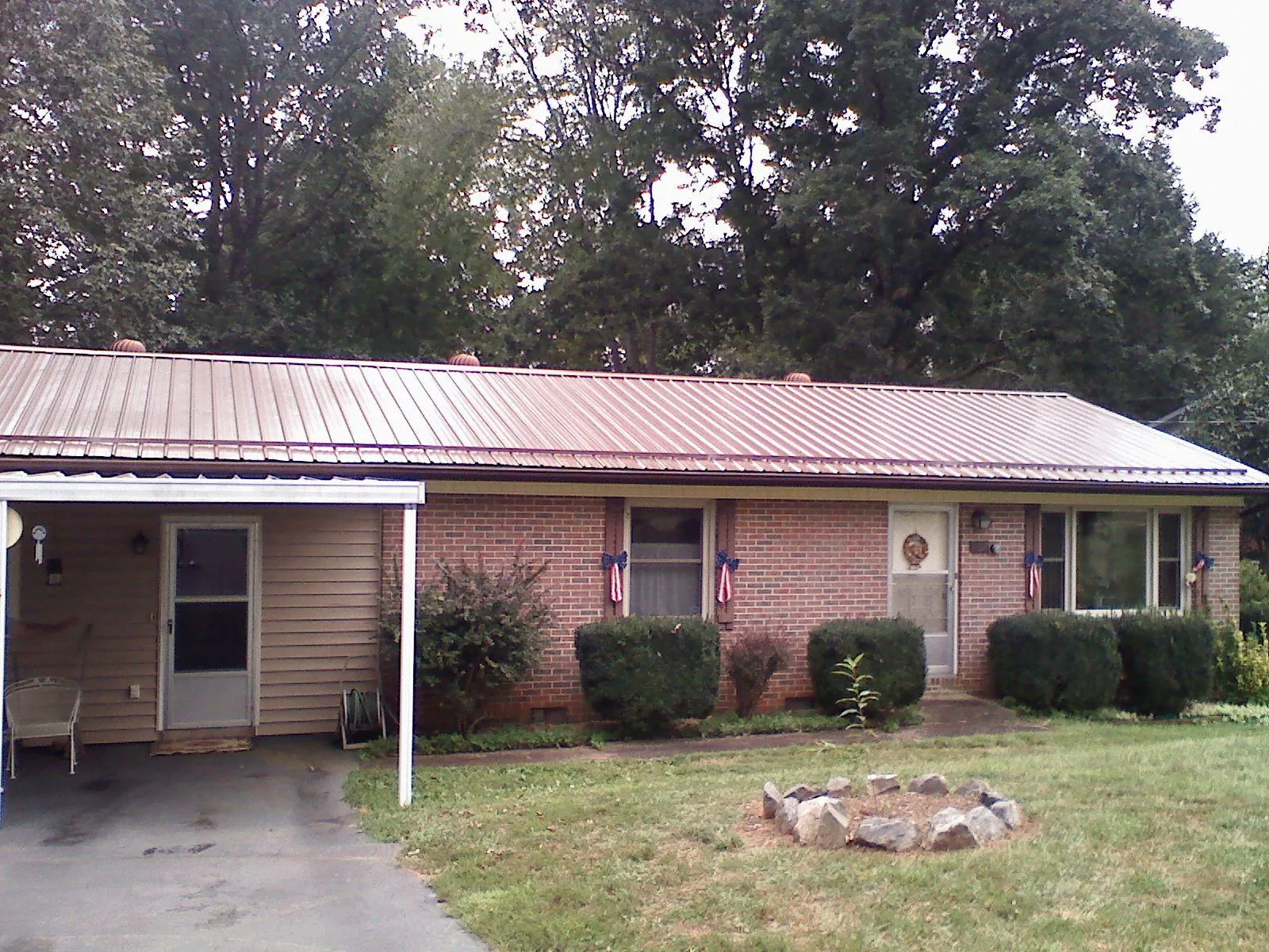 Bronze metal roof and carport on a brick ranch home — Roof Repair work by our crew in New Madison